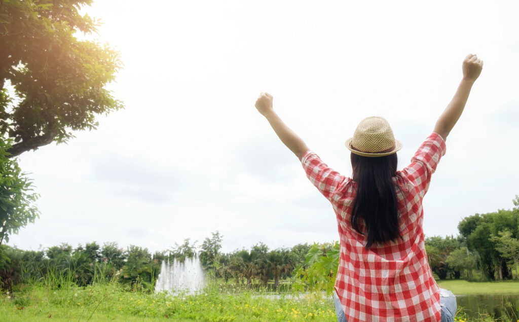 a woman out in nature celebrating her successful recovery from addiction after completing treatment at Transformations Treatment Center in Delray Beach, FL